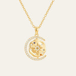 A gold-plated silver necklace with a circular pendant featuring a design with a crescent moon and stars, and a small sun motif at the top center, adorned with small multicolored stones and clear accents.
