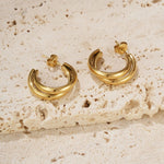 The 'Muse Hoops' from Mettle & Bloom - a pair of double band gold hoop earrings. Crafted with precision, the hoops feature a steel-plated finish for durability and a lustrous appeal. A seamless blend of timeless elegance and contemporary style, these earrings offer a versatile accessory to elevate your look. Available now at Mettle & Bloom, the Muse Hoops embody modern sophistication with their exquisite design.