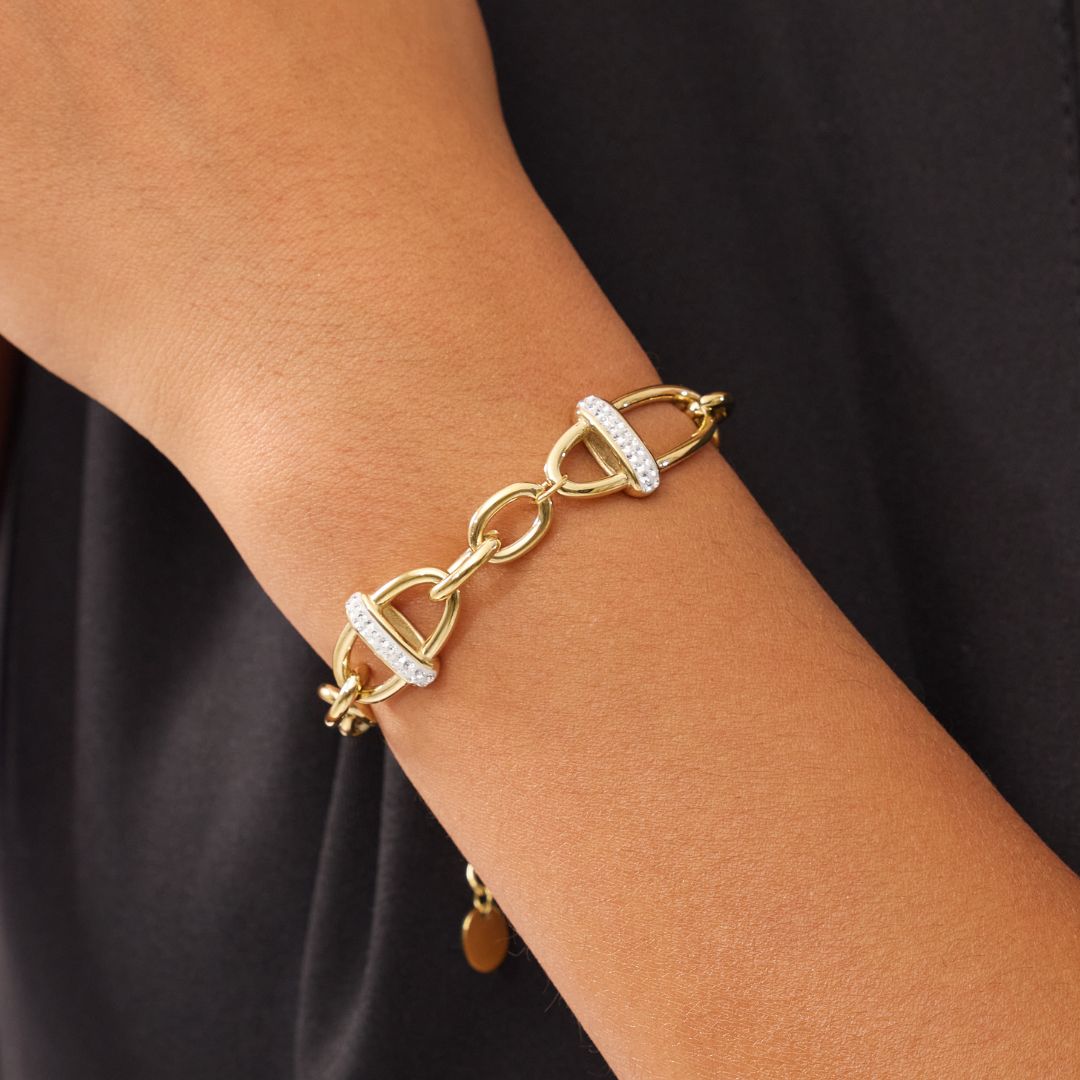 Gold bracelet with diamond accents on a wrist against a black background. Tthis bracelet is an everyday statement, adding a modern glow to both simple and elevated looks.